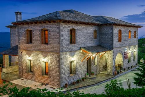 a large brick house with lights on it at Balkoni Zagoriou in Vradeto