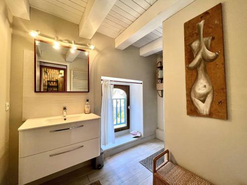 une salle de bain avec un lavabo et un miroir dans l'établissement Charmante maison à Plouhinec, calme et terrasse ensoleillée, animaux acceptés - FR-1-479-213, à Plouhinec