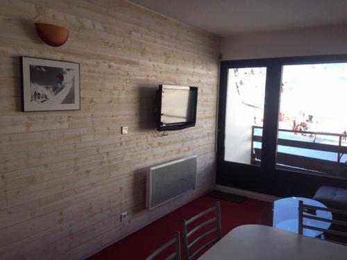 Cette chambre est dotée d'un mur en briques et d'une télévision murale. dans l'établissement Appartement 6 pers, accès pistes, vue montagne - FR-1-602-120, à Arette