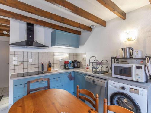 une cuisine avec une table en bois et un micro-ondes dans l'établissement Chalet idéal au cœur de Cauterets, 6-8 pers, parking privé - FR-1-401-315, à Cauterets