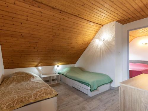 une chambre avec deux lits et un plafond en bois dans l'établissement Chalet idéal au cœur de Cauterets, 6-8 pers, parking privé - FR-1-401-315, à Cauterets