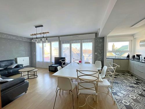 un salon avec une table et des chaises blanches dans l'établissement Appartement spacieux au cœur de Berck-Plage avec balcon et parking - FR-1-646-82, à Berck-sur-Mer