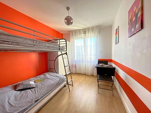 - une chambre avec des lits superposés et un mur orange dans l'établissement Appartement spacieux au cœur de Berck-Plage avec balcon et parking - FR-1-646-82, à Berck-sur-Mer