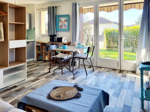 un salon avec une table et une cuisine dans l'établissement Studio avec parking à 2 pas de la plage, Merville-Franceville - FR-1-788-54, à Merville-Franceville-Plage