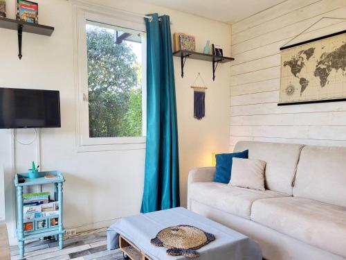 un salon avec un canapé et une fenêtre dans l'établissement Studio avec parking à 2 pas de la plage, Merville-Franceville - FR-1-788-54, à Merville-Franceville-Plage