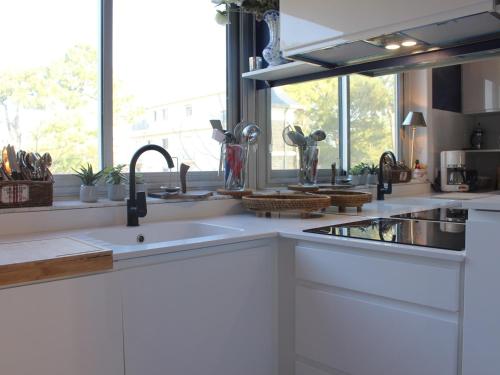 une cuisine blanche avec un évier et une fenêtre dans l'établissement Appartement 3 pièces rénové face mer - 4 personnes La Baule - FR-1-245-211, à La Baule