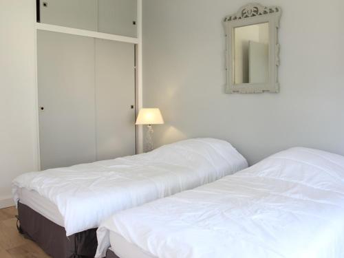 - 2 lits blancs dans une chambre avec un miroir dans l'établissement Appartement 3 pièces rénové face mer - 4 personnes La Baule - FR-1-245-211, à La Baule