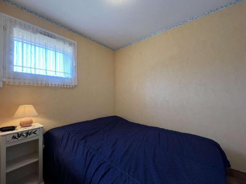 une chambre avec un lit bleu et une fenêtre dans l'établissement Appartement 2P avec terrasse à Gruissan - FR-1-229-892, à Gruissan