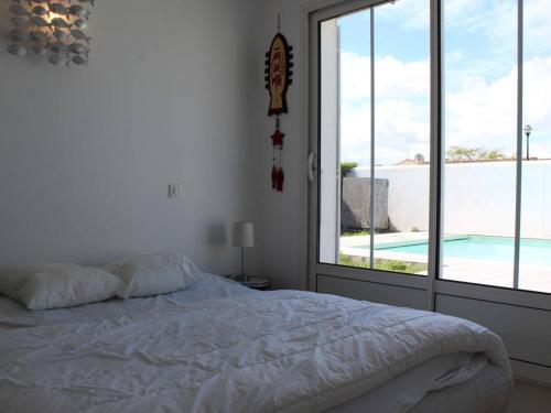 une chambre avec un lit et une vue sur une piscine dans l'établissement Maison contemporaine avec piscine chauffée sur l'île d'Oléron - FR-1-246A-340, à La Brée-les-Bains