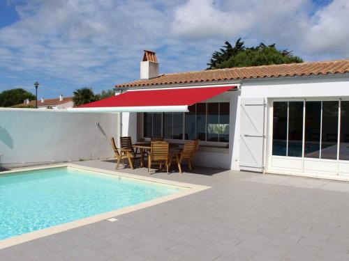 un patio avec une table et des chaises et une piscine dans l'établissement Maison contemporaine avec piscine chauffée sur l'île d'Oléron - FR-1-246A-340, à La Brée-les-Bains