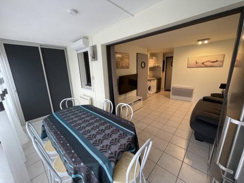 une chambre avec une table et des chaises ainsi qu'un salon dans l'établissement Appartement rénové à 300m de la plage avec parking - FR-1-723-170, au Cap d'Agde
