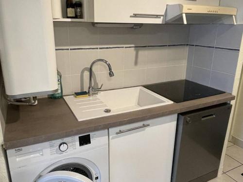 une cuisine avec un évier et une machine à laver dans l'établissement Appartement rénové à 300m de la plage avec parking - FR-1-723-170, au Cap d'Agde