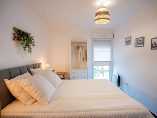 a bedroom with a large bed with white sheets at Appartement T2 avec grande terrasse et parking - FR-1-553-291 in Balaruc-les-Bains