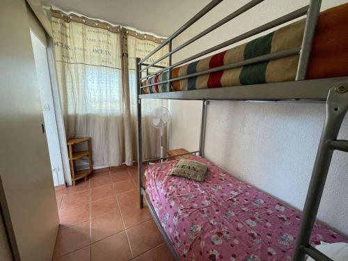 - une chambre avec des lits superposés et un couvre-lit rose dans l'établissement Appartement avec piscine, animaux admis, parking, plage à Port Camargue, 4 pers. - FR-1-250-296, au Grau-du-Roi