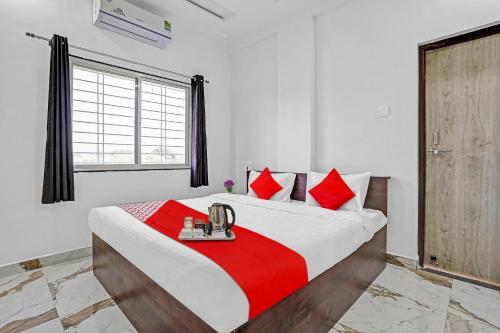 a bedroom with a large bed with red pillows at Hotel O Yashraj Inn in Nagpur
