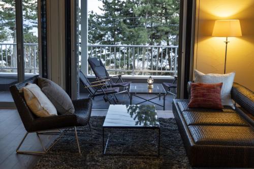 Una sala de estar con un sofá y sillas y una mesa. en 高島畔舎, en Takashima