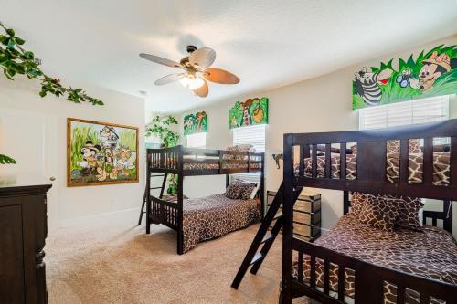 Zimmer mit 2 Etagenbetten und einem Deckenventilator. in der Unterkunft Universal 3BR Townhome with Pool in Davenport