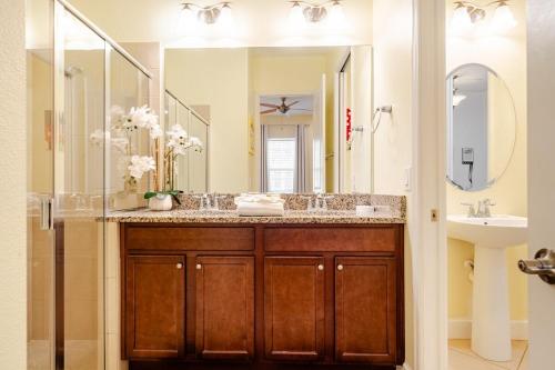 ein Badezimmer mit Waschbecken und großem Spiegel in der Unterkunft Universal 3BR Townhome with Pool in Davenport