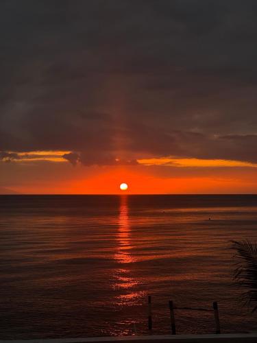 a sunset over the ocean with the sun setting at OIA by Seascape in Bauan