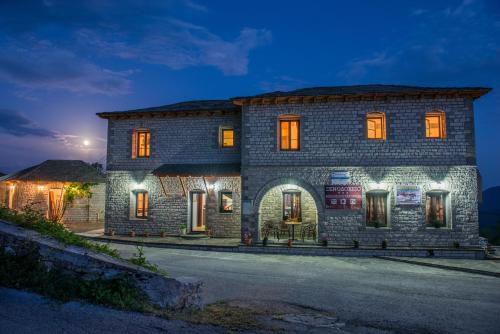 a stone house with lights on it at night at Balkoni Zagoriou in Vradeto