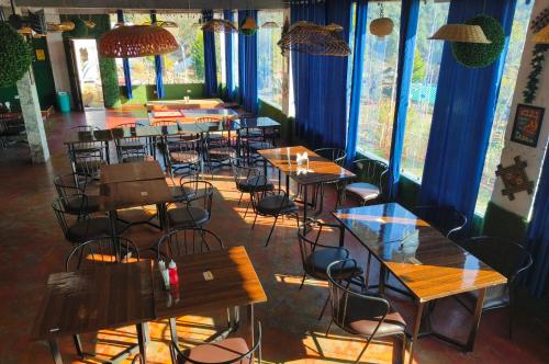 a row of tables and chairs in a restaurant at Hill Ventures Adventure Camp and Restaurant in Dharamshala