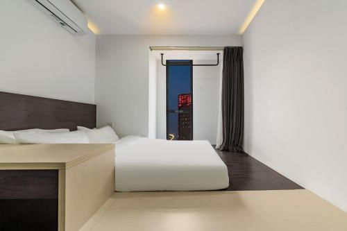 a bedroom with a white bed and a desk at Merica Hotel - Hangzhou Canal Branch in Hangzhou