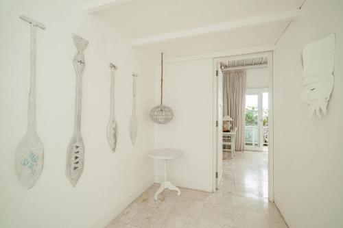 a white room with utensils hanging on the wall at Gravity Boutique Suites in Uluwatu