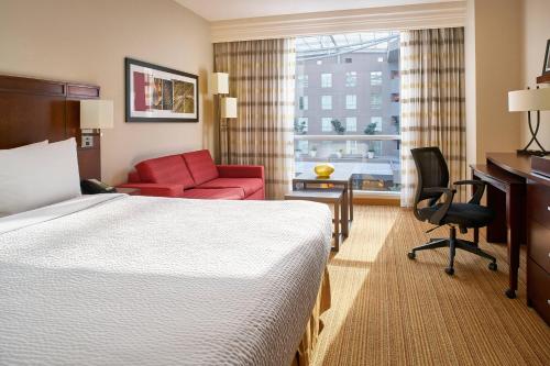 a hotel room with a bed and a desk and a chair at Courtyard by Marriott Mexico City Airport in Mexico City