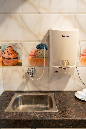 a kitchen counter with a mixer and a sink at Tranquill Studio Stays with Hottub in Nagoa-Bardez