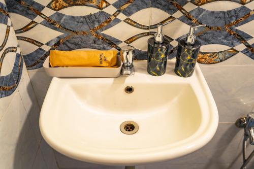 a bathroom sink with two pairs of shoes on it at Tranquill Studio Stays with Hottub in Nagoa-Bardez