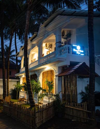 a white house with a balcony at night at Tranquill Studio Stays with Hottub in Nagoa-Bardez
