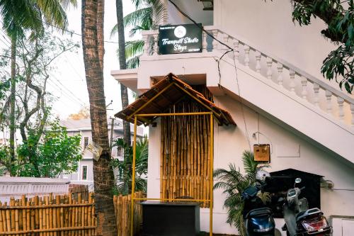 a building with a motorcycle parked in front of it at Tranquill Studio Stays with Hottub in Nagoa-Bardez