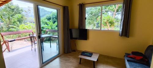 un soggiorno con TV e porta scorrevole in vetro di Alisa Bungalows a Ko Chang