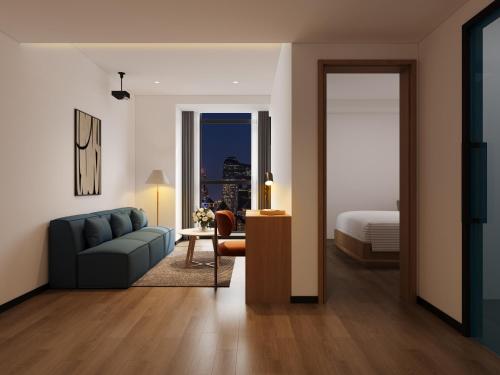 a living room with a couch and a bed at Merica Hotel - Hangzhou Canal Branch in Hangzhou
