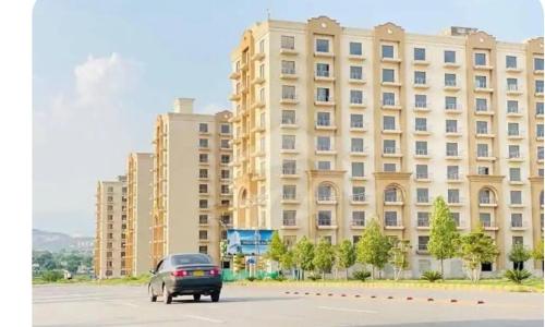 a car parked in a parking lot in front of a building at Studio Murree facing apartment In Bahria Enclave in Islamabad