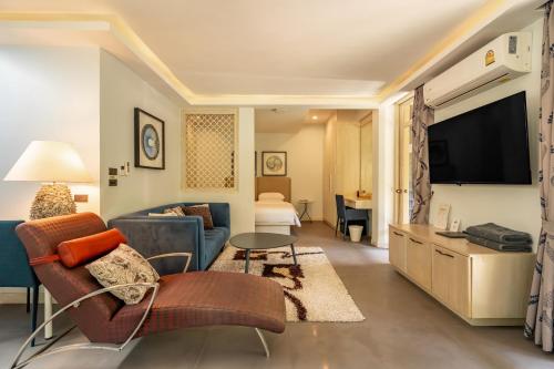 a living room with a couch and a tv at Ocean Pearl Seaview Residence in Rawai Beach