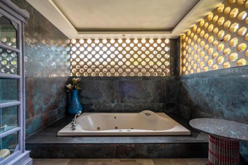 a bath tub in a bathroom with a table at Ocean Pearl Seaview Residence in Rawai Beach