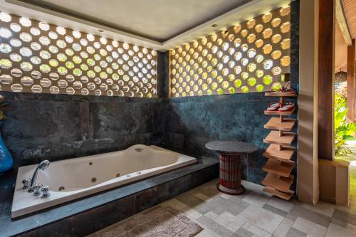 a bathroom with a tub and a table at Ocean Pearl Seaview Residence in Rawai Beach