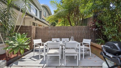 a table and chairs on a patio with a fence at Brunswick Beach Club - Coastal Comfort Near Beach in Coffs Harbour
