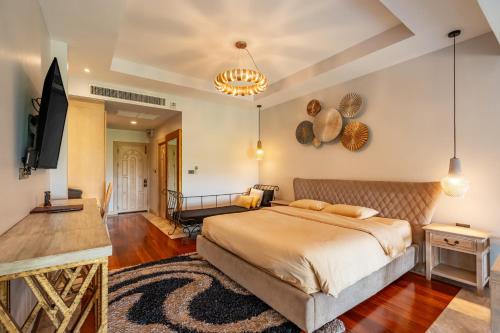 a bedroom with a large bed and a flat screen tv at Ocean Pearl Seaview Residence in Rawai Beach