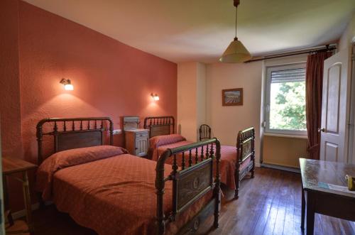 a bedroom with two beds and a window at Hostal Ayestaran I in Lekunberri