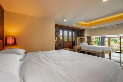 a hotel room with two beds and a balcony at Ocean Pearl Seaview Residence in Rawai Beach