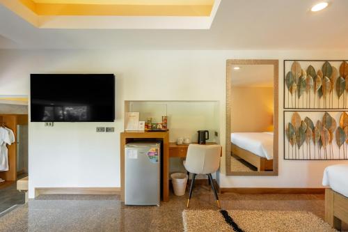 a room with a television and a bed and a mirror at Ocean Pearl Seaview Residence in Rawai Beach