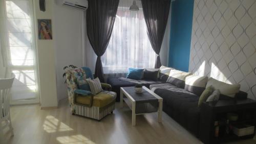 a living room with a couch and a chair at Apartment Sophie in Plovdiv