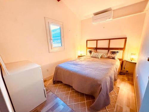 une chambre avec un lit et une fenêtre dans l'établissement La plage à 2min à pied, 2 extérieurs,wifi,Clim, au Barcarès