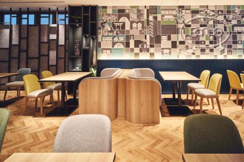 un ristorante con tavoli, sedie e un muro di Holiday Inn Kyoto Gojo a Kyoto
