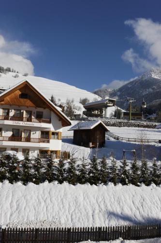 a snow covered building with a bunch of christmas trees at Villa Ortensia in San Vigilio Di Marebbe