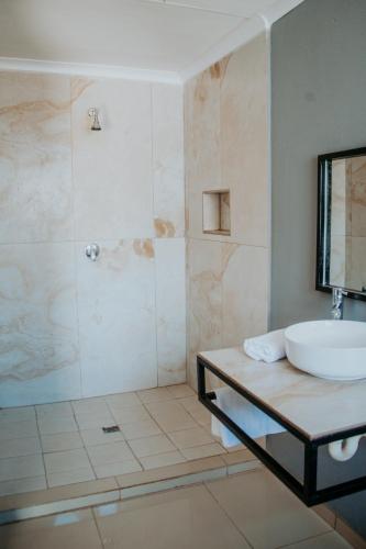 a bathroom with a sink and a shower at Karabelo guesthouse in Groblersdal
