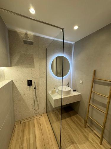 a bathroom with a shower and a sink and a mirror at Artemis Apartments in Diakopto
