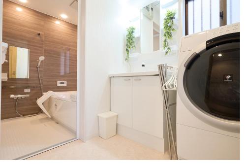 a bathroom with a washer and dryer in a room at KANAKO GUEST HOUSE 1号館 osaka in Osaka